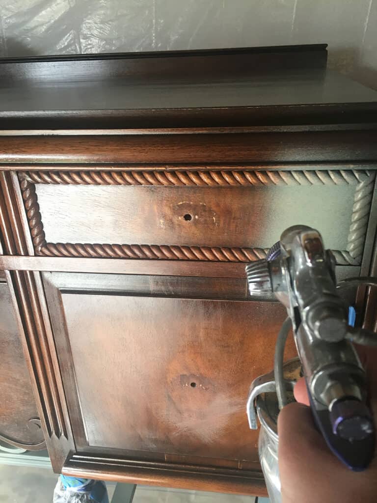 antique buffet in front of paint sprayer