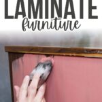 A hand painting pink paint onto laminate furniture, with text: Best Paint for Laminate Furniture.