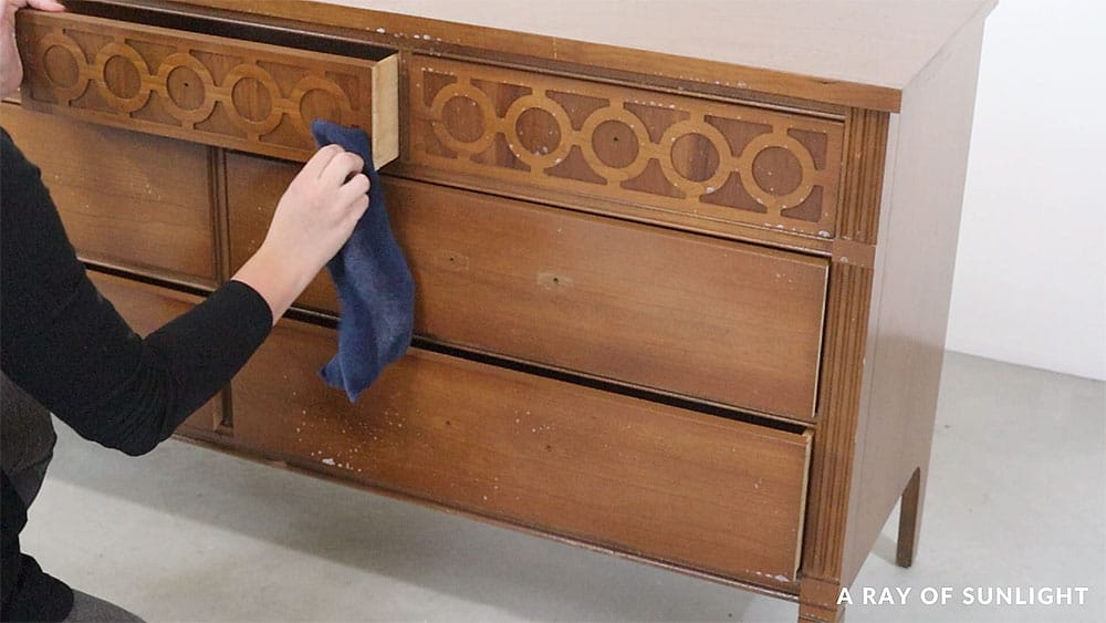 Cleaning the dirt and grime off a dresser with Krud Kutter and a damp rag.