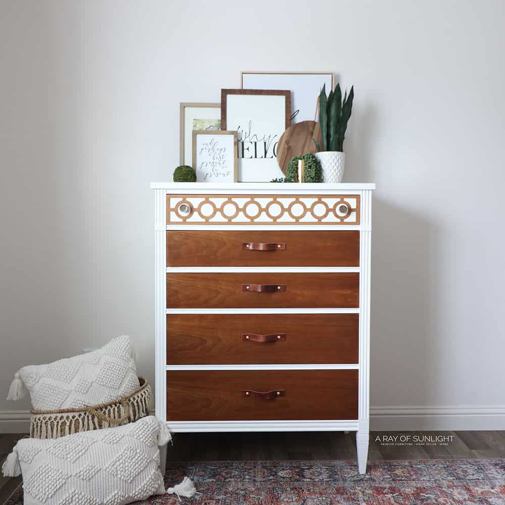 Full view of white painted dresser with wood drawers and leather pulls.
