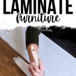 Person painting white paint on brown laminate furniture, with text: Best Paint for Laminate Furniture.