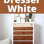 Vintage wooden dresser with white accents and open circle design, styled with decorative plants and framed art.
