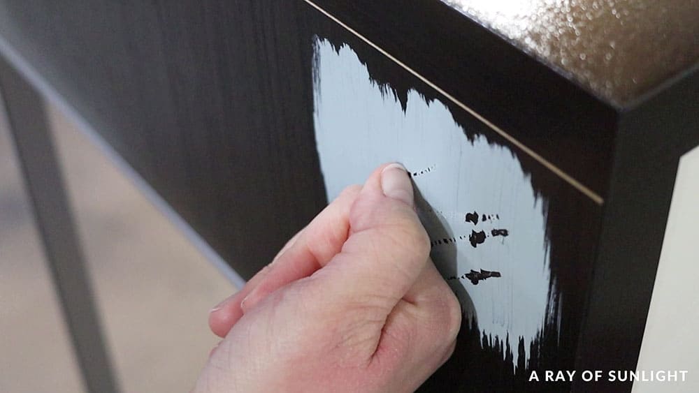 scratching paint off of a laminate desk with finger