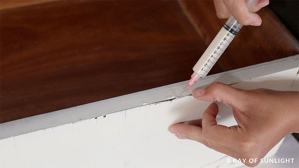 Gluing peeling veneer back onto the drawers using a glue syringe