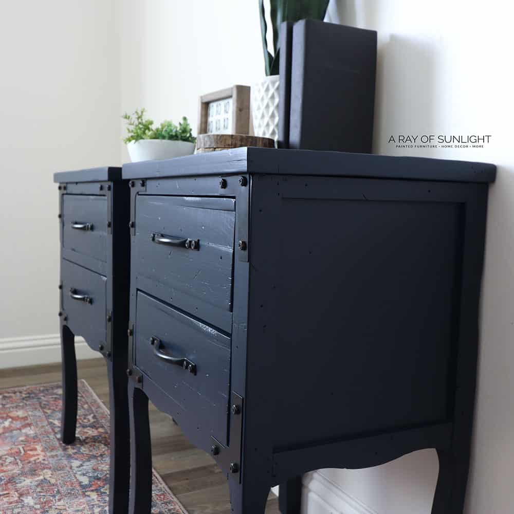 Close side view of navy blue painted nightstands with black hardware