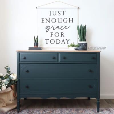 green painted dresser with natural wood top and black knobs