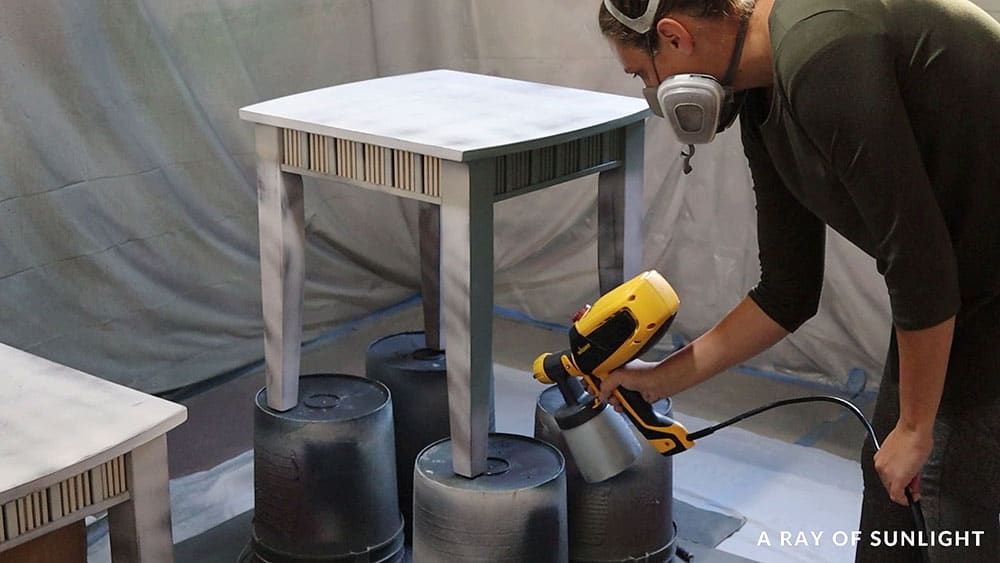 spraying heirloom traditions paint on the end tables