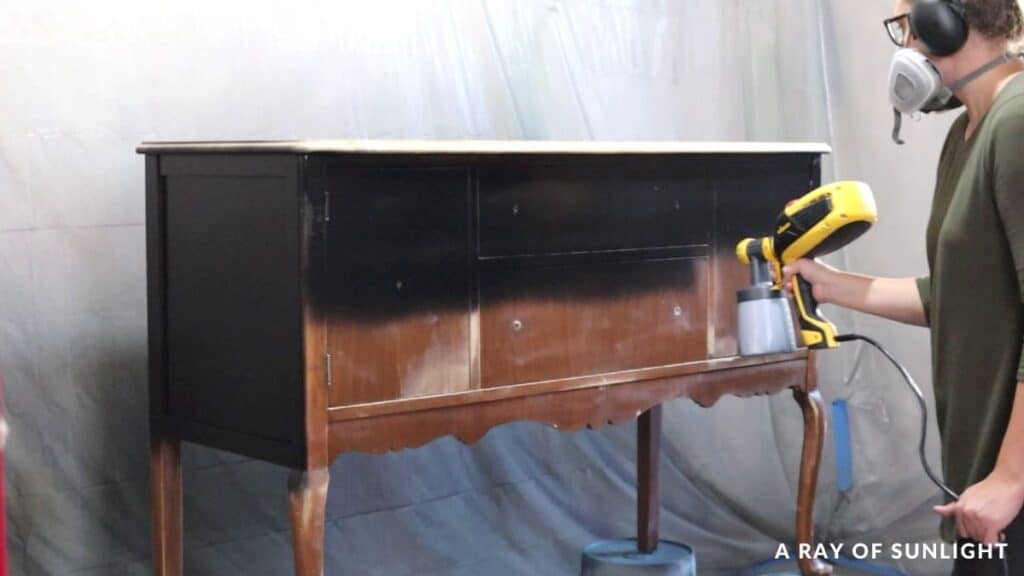 Spraying black chalk paint on the buffet with Wagner sprayer