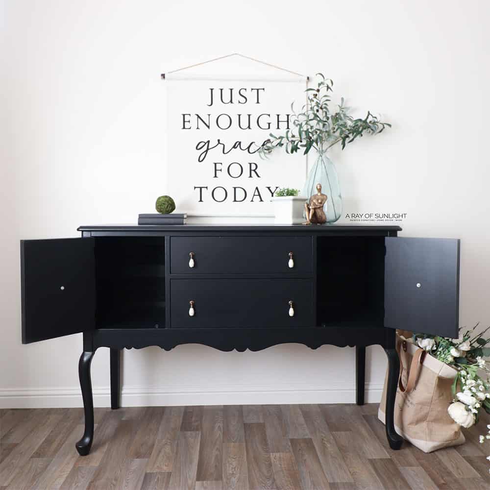 Black painted buffet with cabinet doors open.