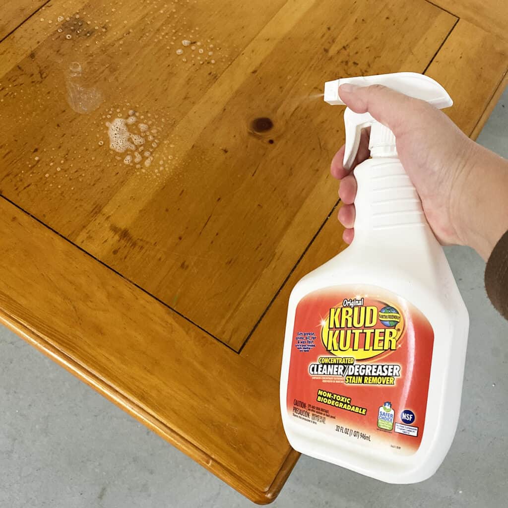 spraying furniture with cleaner