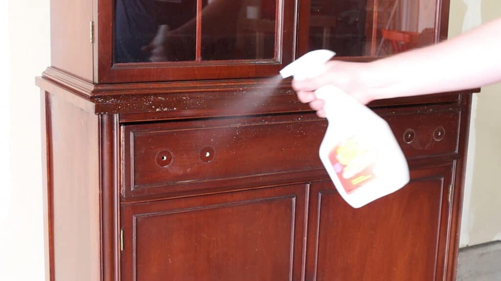 spraying krud kutter cleaner on china cabinet