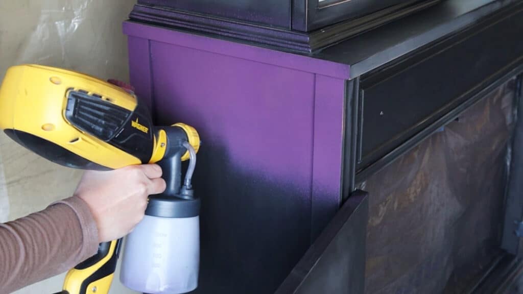 spraying purple paint on furniture