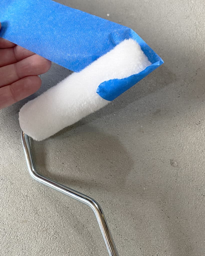 removing fibers from paint roller with painters tape before using the roller