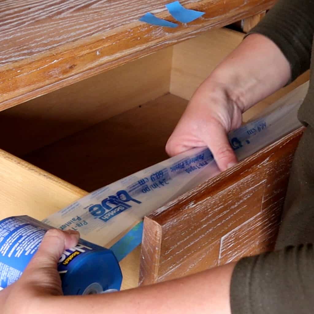 putting tape and plastic on drawers