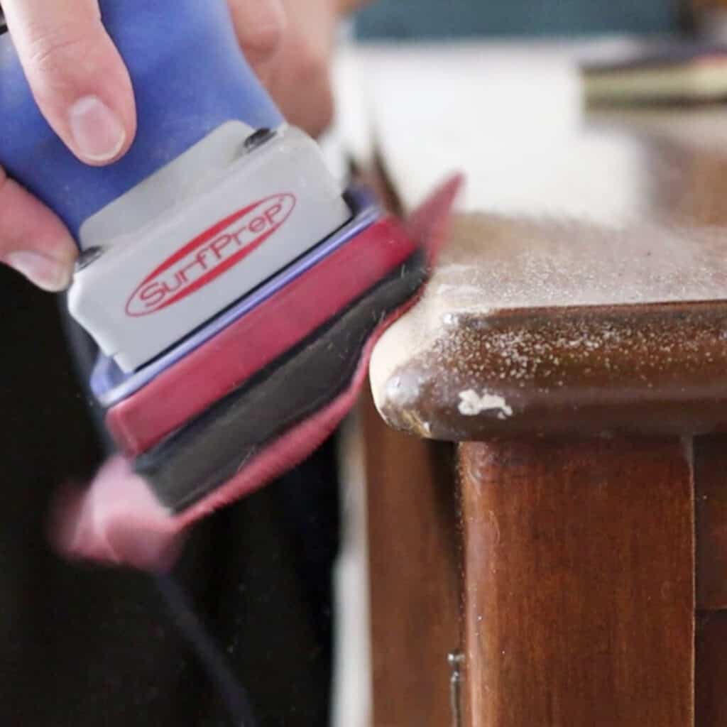 sanding the curved edge of a buffet with surfprep electrical sander
