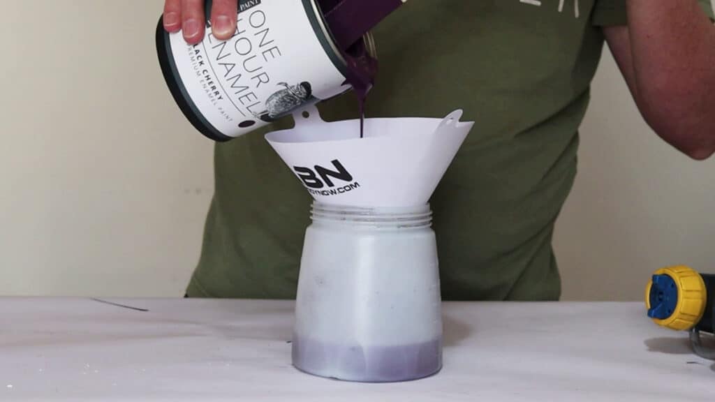 pouring enamel paint into a filter