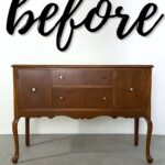 A vintage wooden sideboard under the word “before” in large, cursive black letters on a white wall.