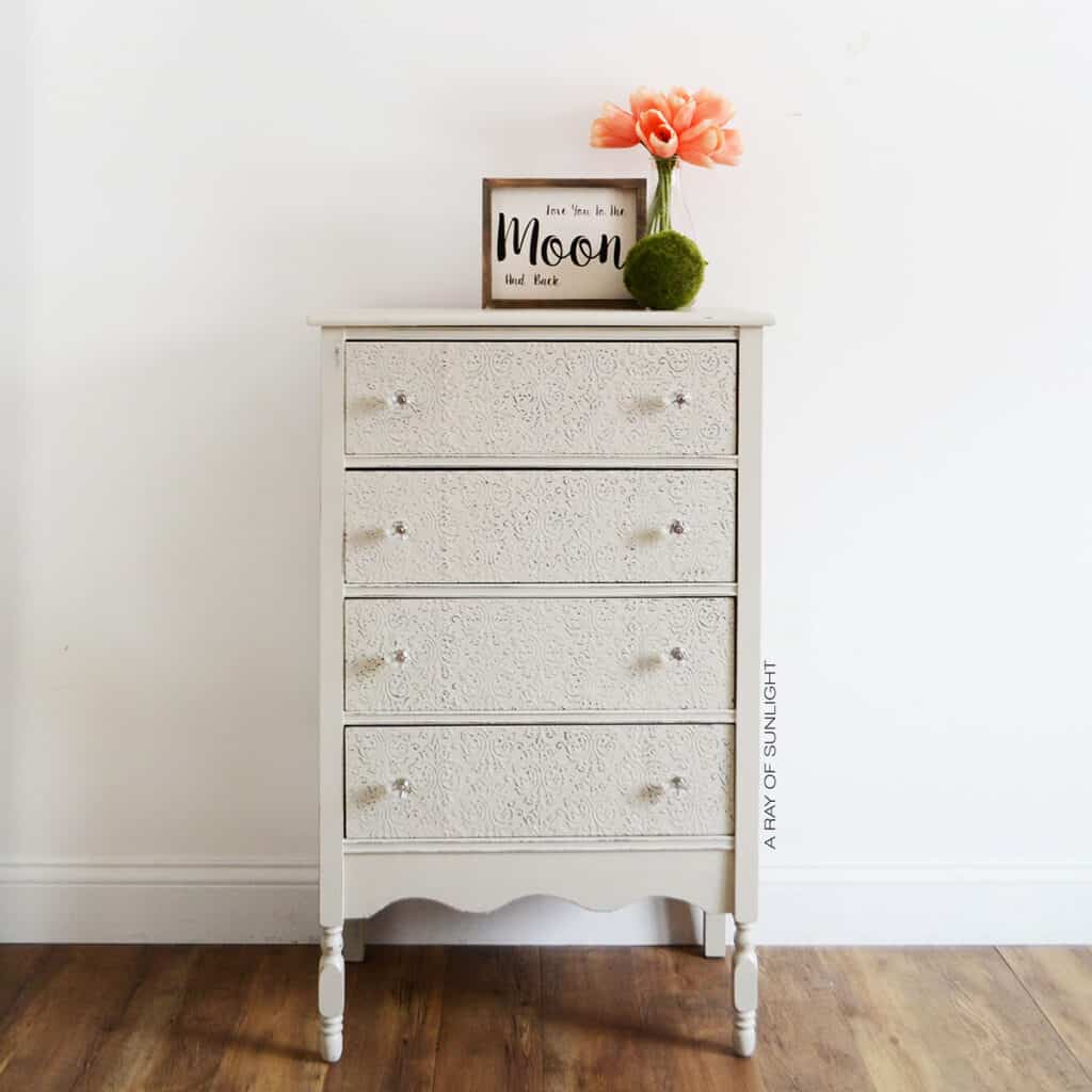 grey painted chest of drawers with embossed drawers and crystal knobs