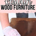 Gloved hand wiping stain onto wood furniture with text: How to Restain Wood Furniture.