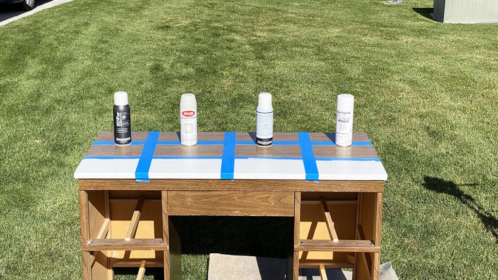 different chalk paint spray cans on top of a laminate desk