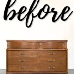 A wooden dresser under the word before written in large, black cursive letters on a white wall.