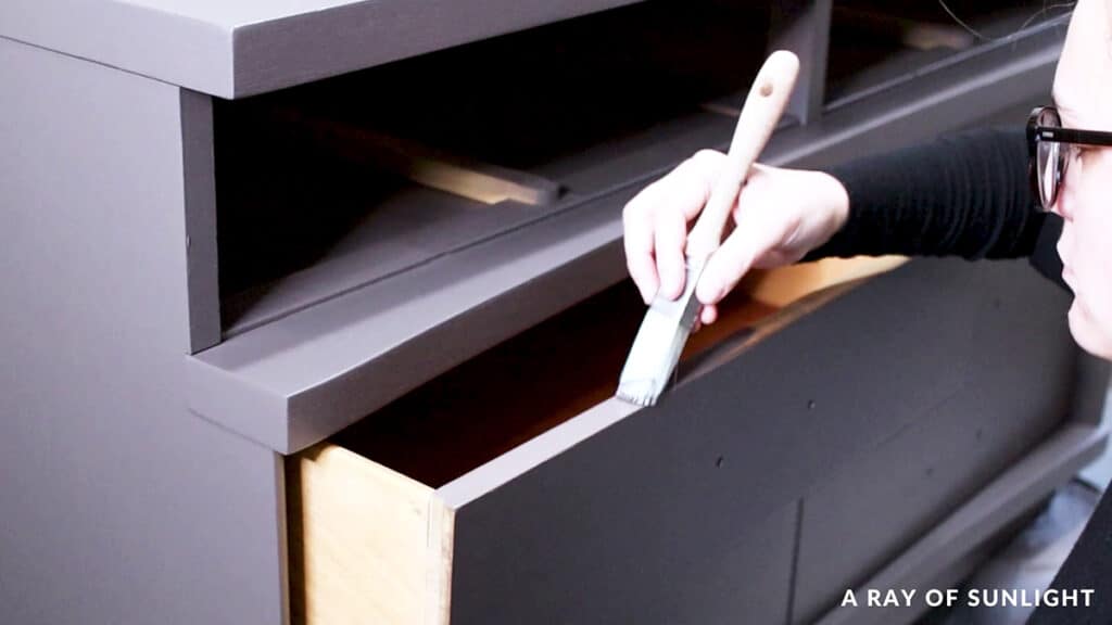 brushing paint onto the edges of the drawer