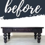 A dark wooden coffee table with a drawer, under the word before in large script on a painted backdrop.