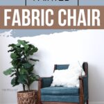 A teal blue chalk painted fabric chair with a white pillow beside a potted plant on a wood floor.