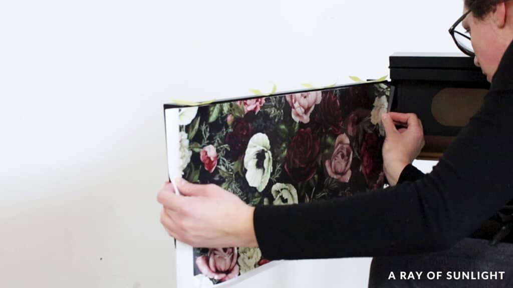 applying a dark romance floral transfer onto the inside of the door