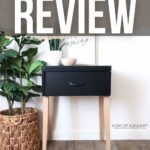 Black painted table with light wood legs, plant basket, and decor