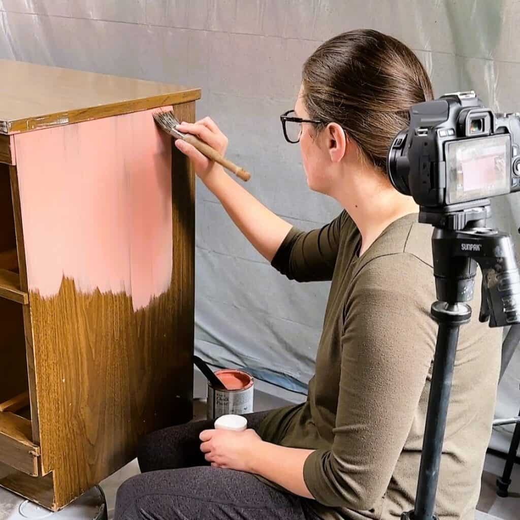 natalie of a ray of sunlight painting furniture with a camer recording her