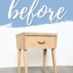 A small, plain wooden sewing table with a drawer