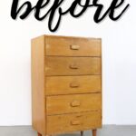 A plain wooden dresser with five drawers and the word before written above it in script.
