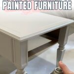 Hand holding spray can of polycrylic near a white painted table