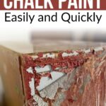 A wooden surface with peeling red and white chalk paint being removed.