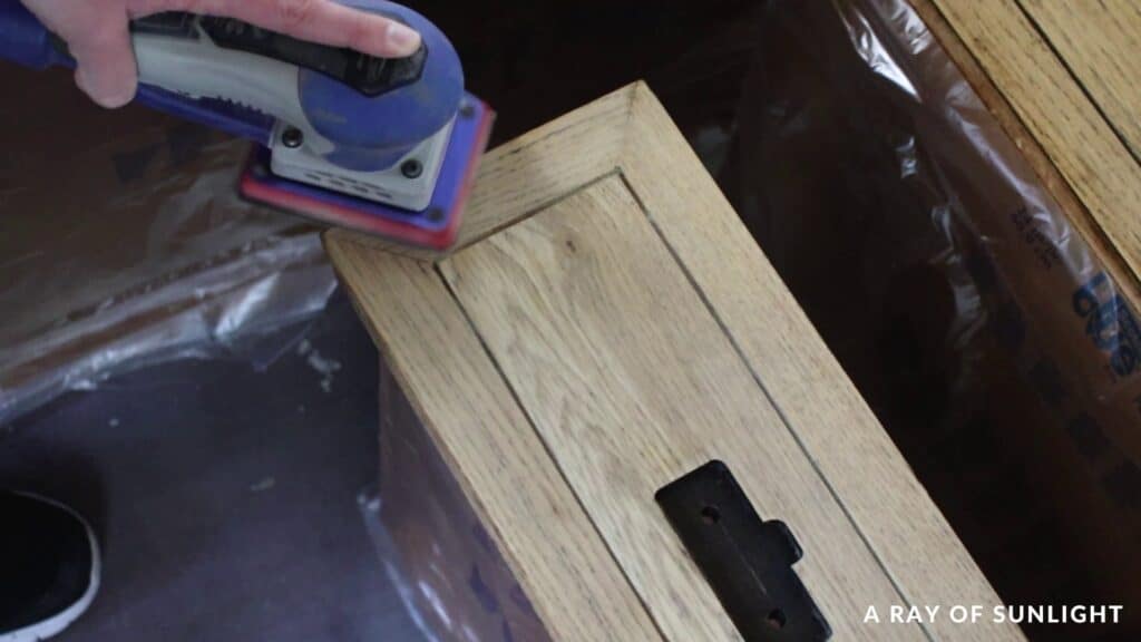 sanding the wood drawer in the direction of the wood grain