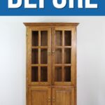 A wooden cabinet with glass doors labeled BEFORE at the top in bold white letters on a blue background.
