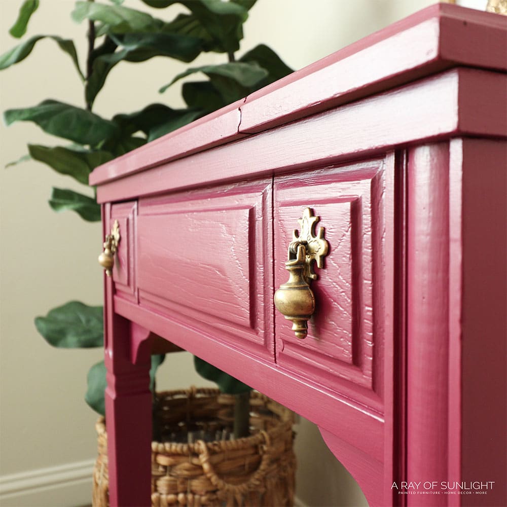 closeup of pink painted sewing table with gold hardware