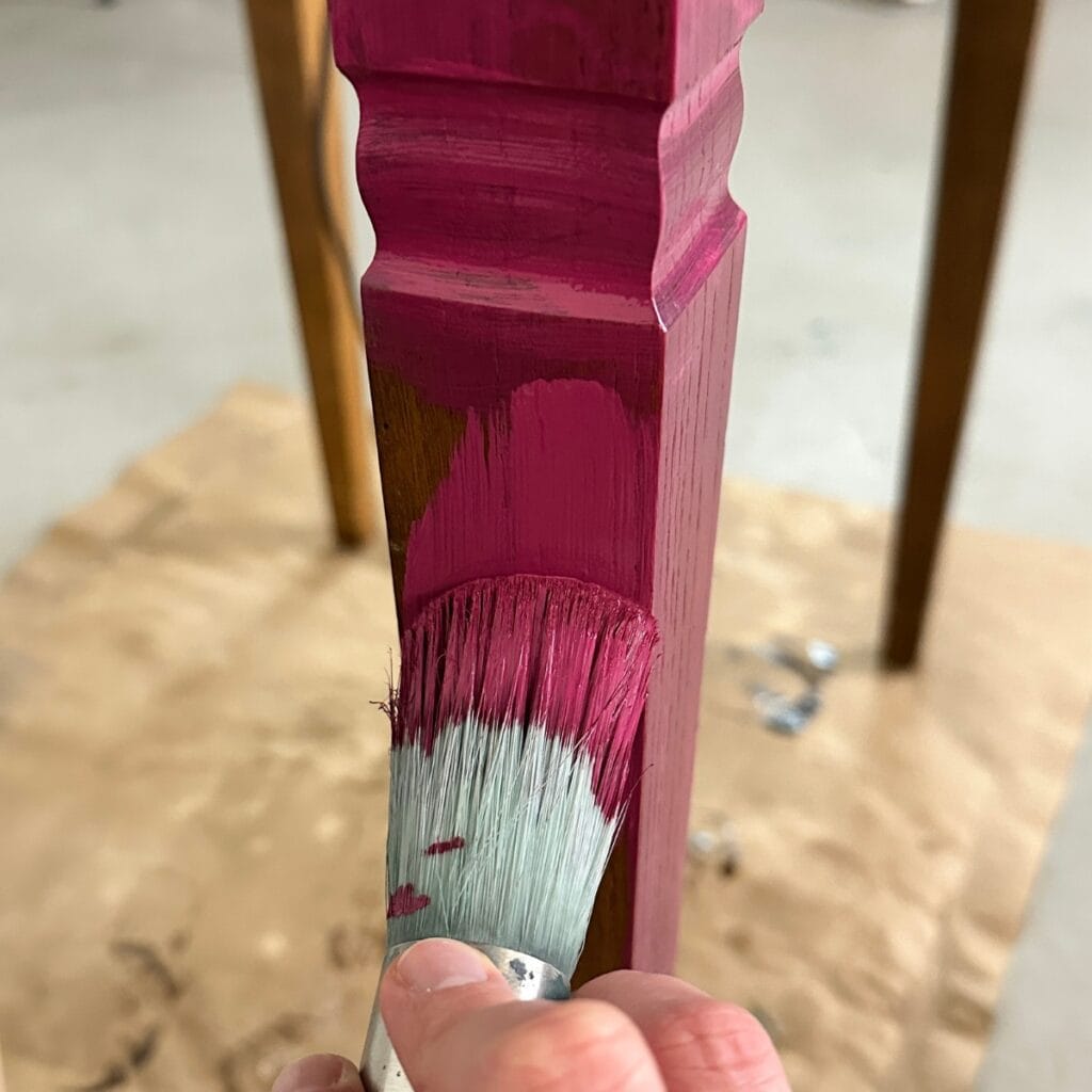 brushing rethunk junk paint in wild berry onto table