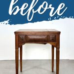 an old sewing machine table with black handles pictured in a white wall background