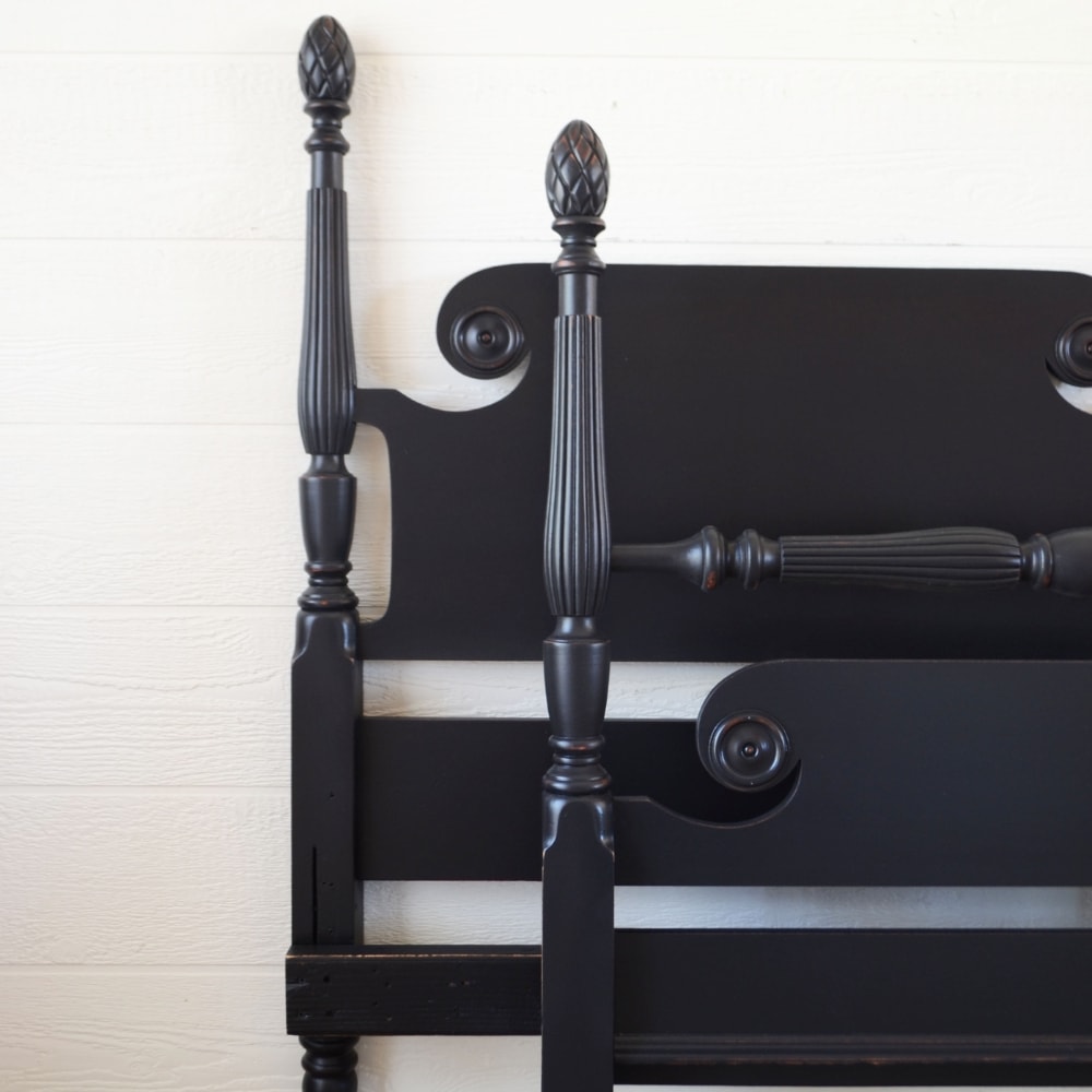 closeup of a black painted antique bed frame