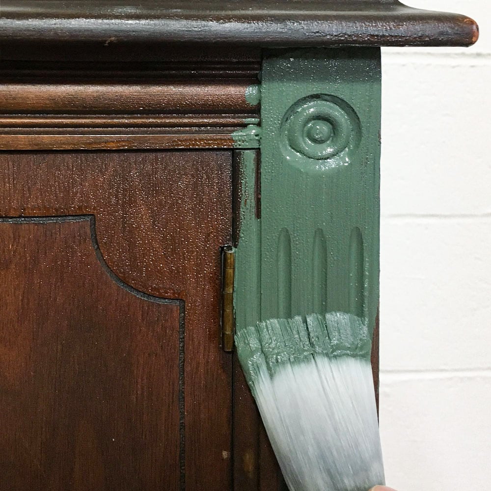 brushing on paint into furniture with high quality paint brush