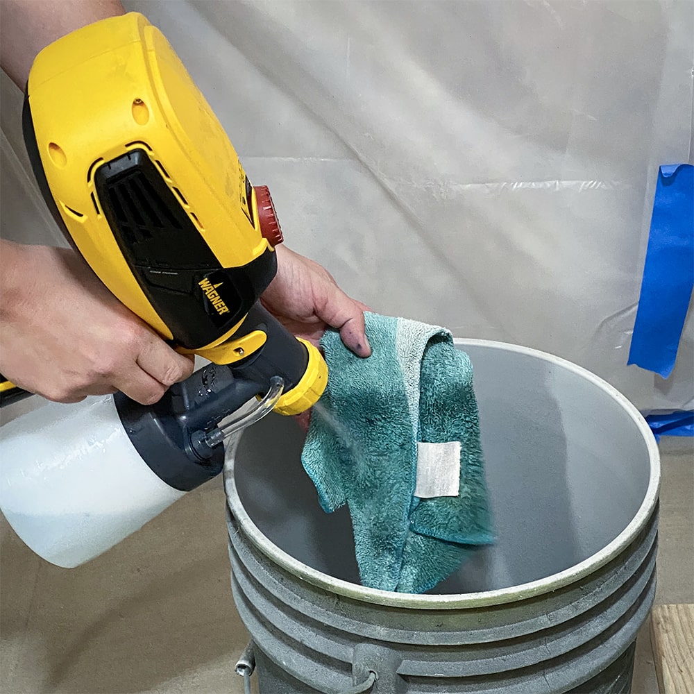 cleaning inside of the sprayer by spraying with cleaning solution into a bucket