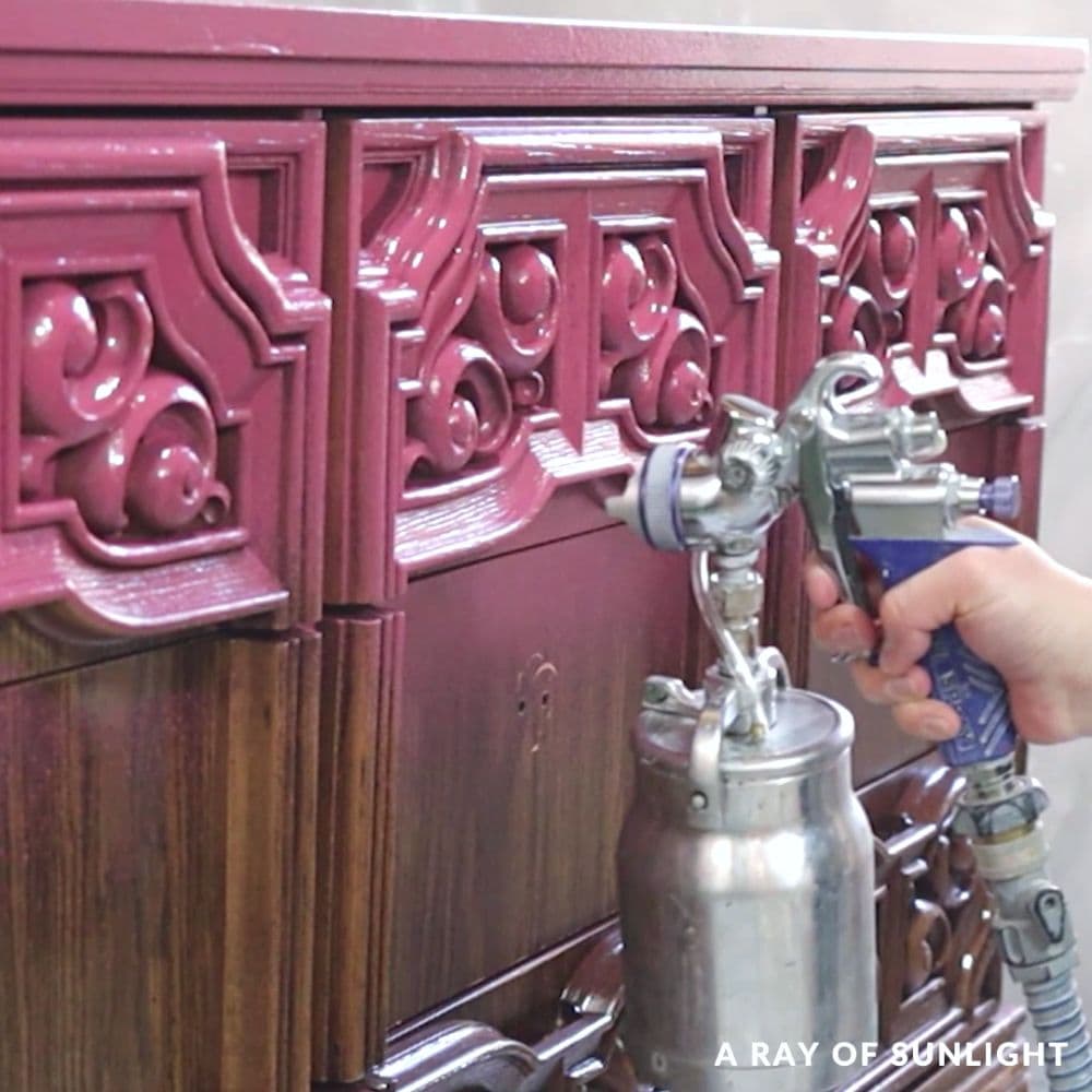 spraying a dresser with pink paint