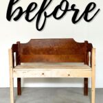 A wooden bench against a white wall with before written in large black script above it.