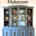 A large blue painted hutch with glass doors