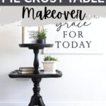 Black antique pie crust table with plants in front of a wall art