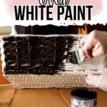 A person applies dark gel stain over white paint on a woven basket with a paintbrush.