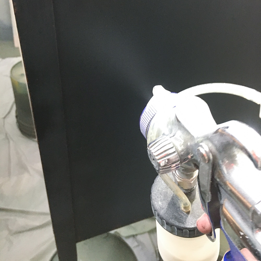 applying waterbased polyurethane onto dresser with paint sprayer