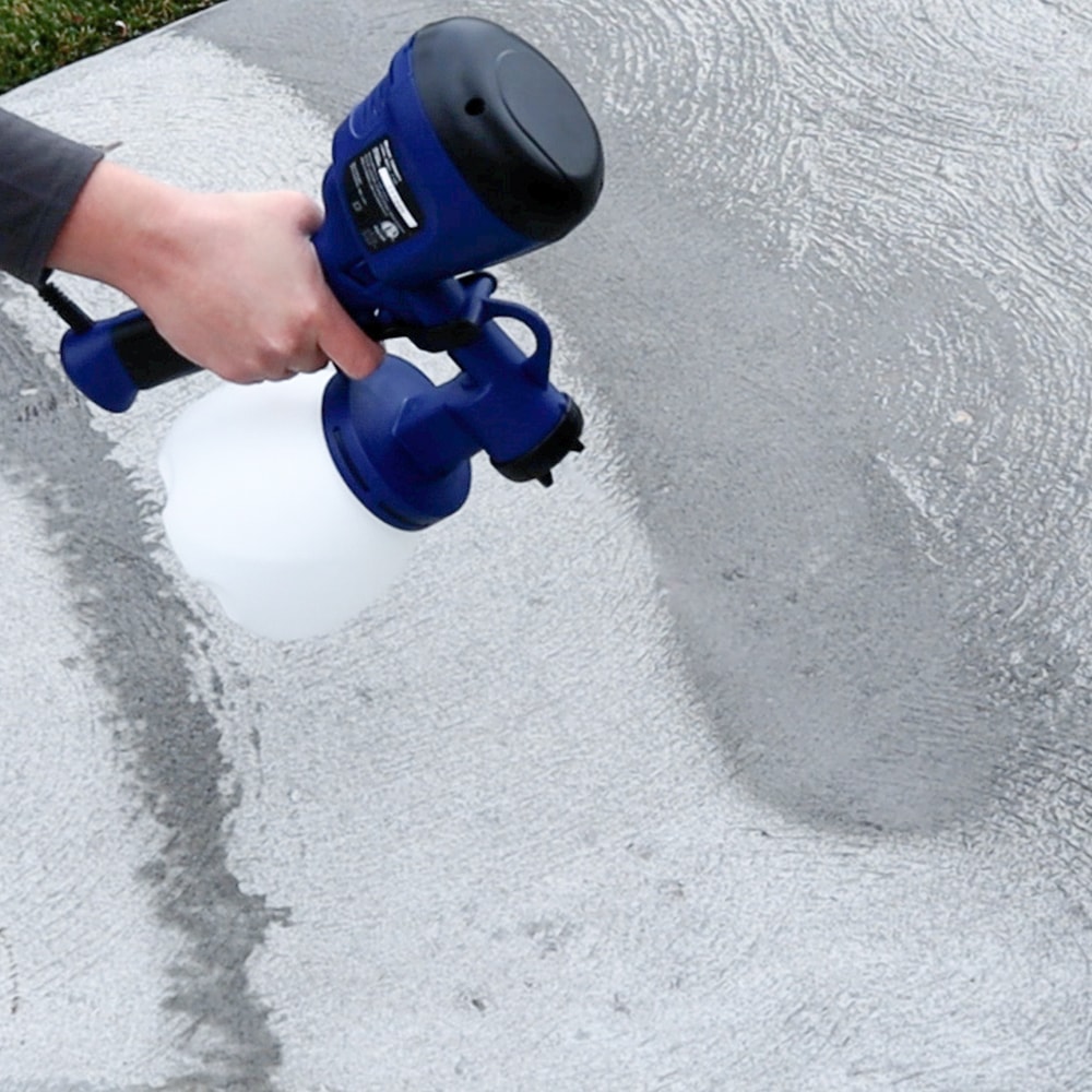 trying out paint sprayer with water onto cement